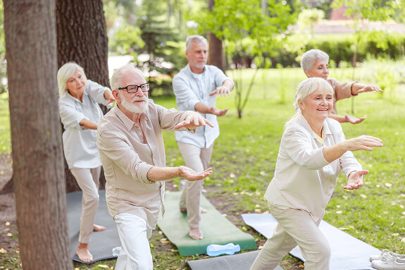 Adultos mayores practicando chi kung en el parque