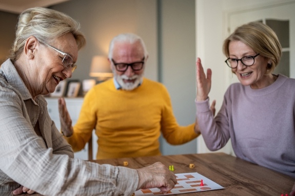 Personas mayores jugando a juegos de mesa juntos, actividad cognitiva y social para prevenir el deterioro