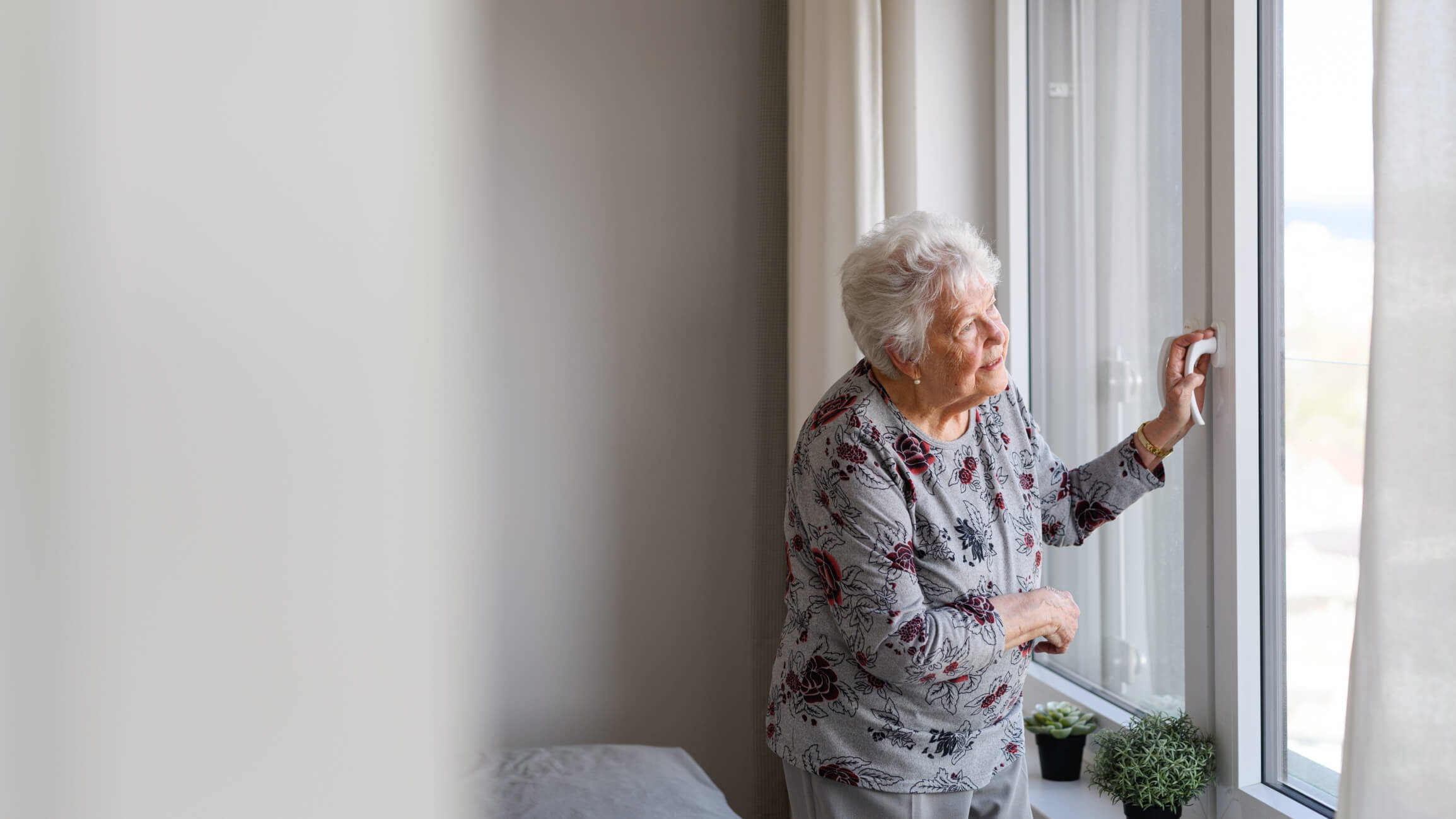 mujer mayor mirando por la ventana