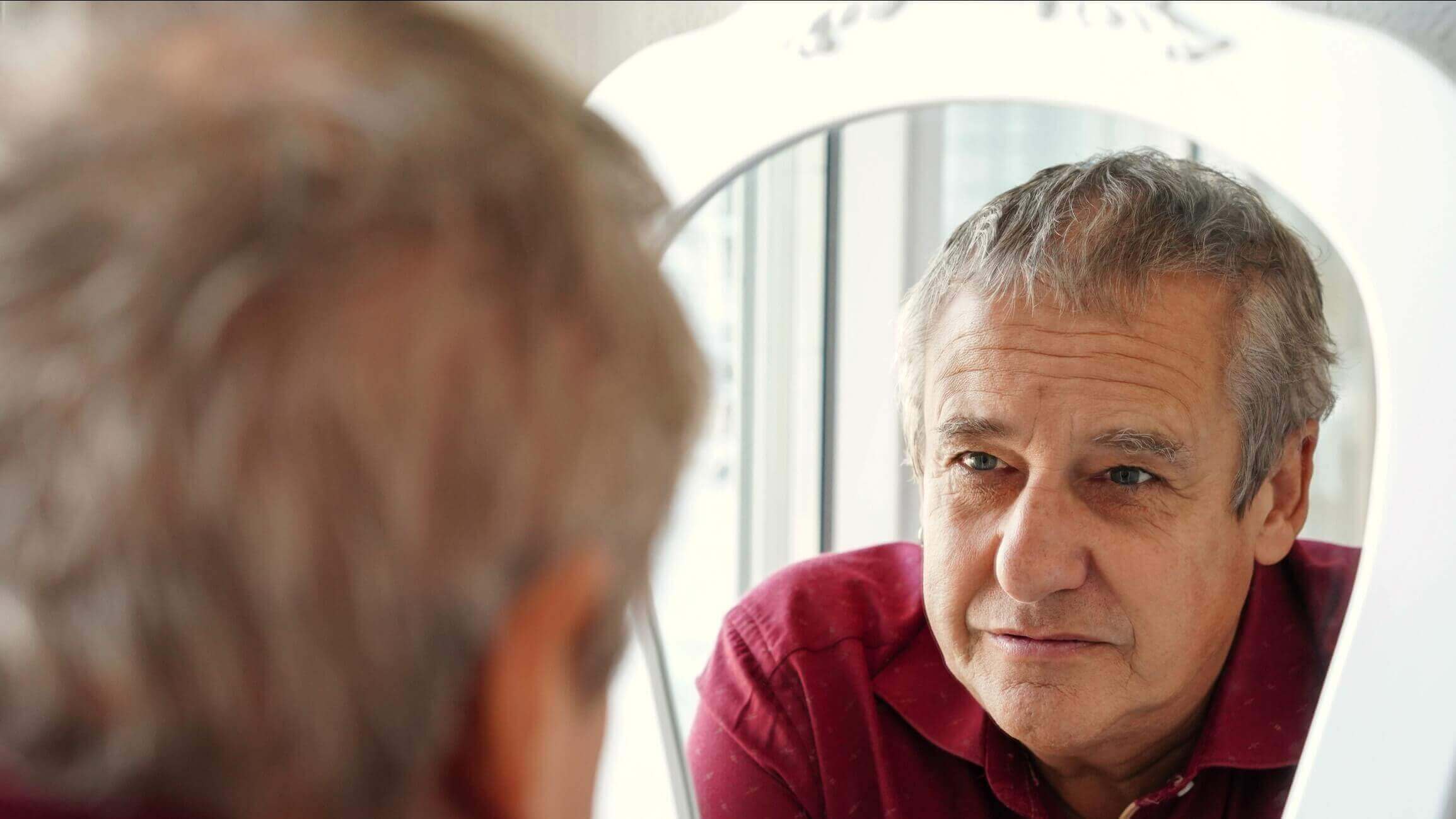 Persona con Alzheimer en sus primeras fases reflexionando en su entorno cotidiano